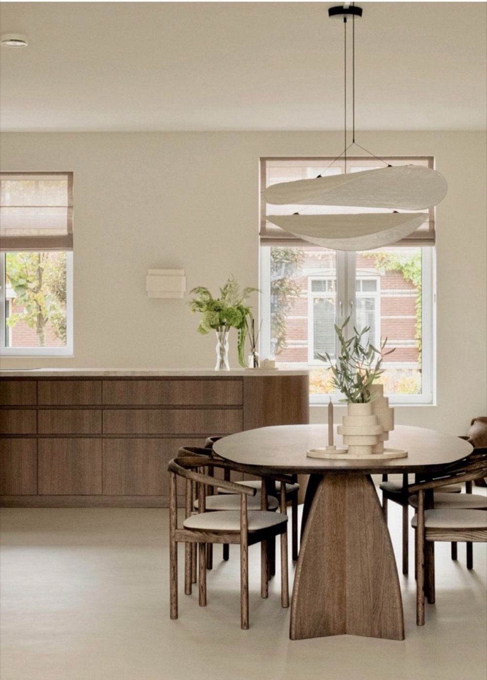 Eetkamer met ovale eikenhouten tafel, houten stoelen en linnen hanglamp