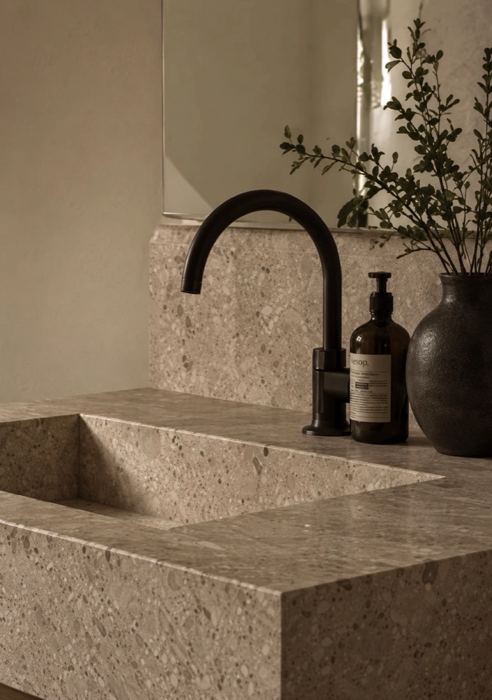 Terrazzo wastafel met zwarte kraan